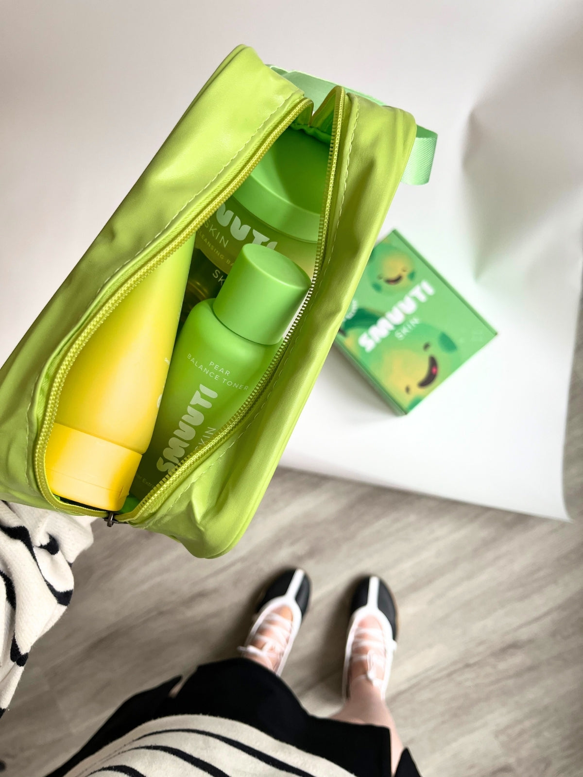 Green bag with Smuuti Skin products and a box on a light-colored surface