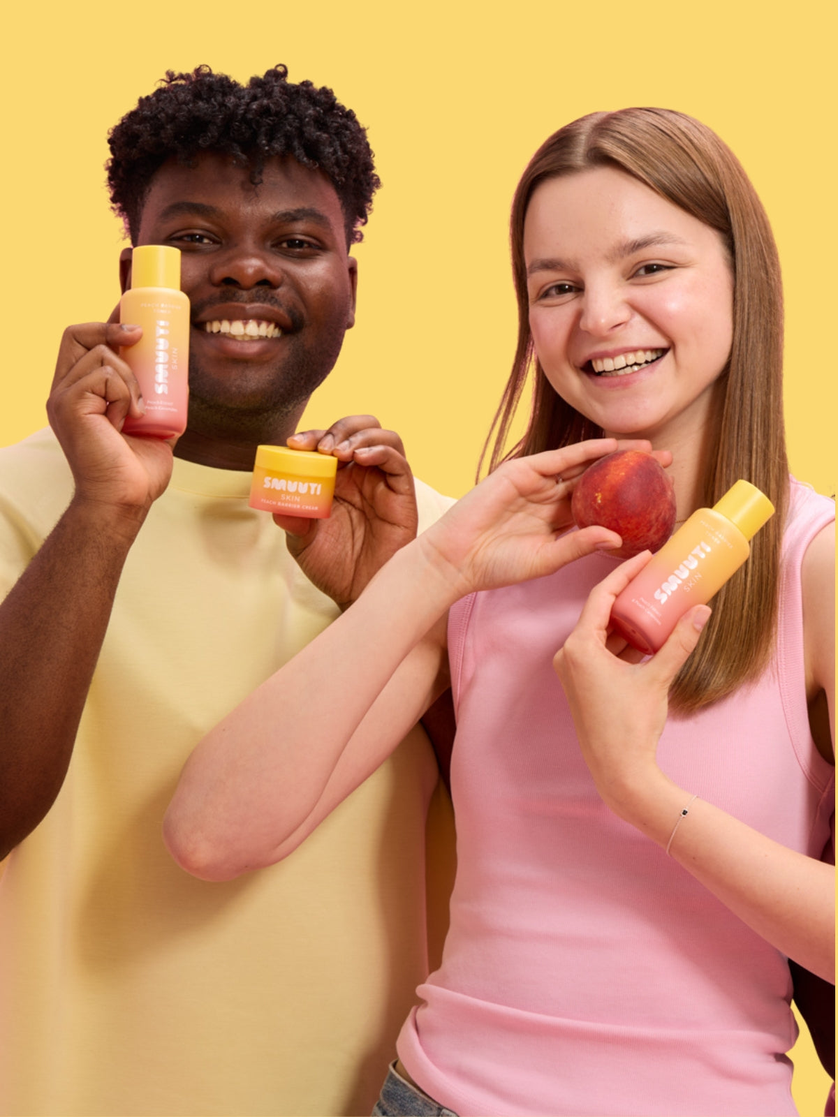 two people holding peach barrier skincare products