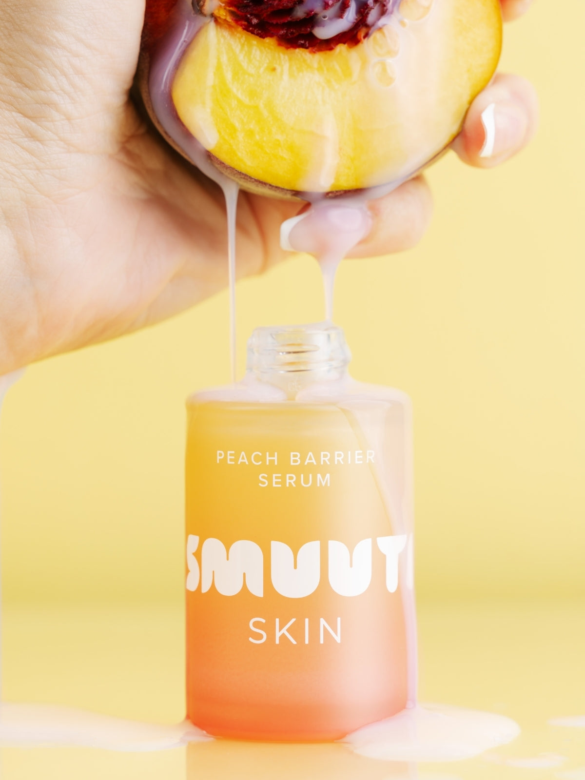 Peach barrier serum being dripped onto a peach and flowing into the peach barrier serum bottle