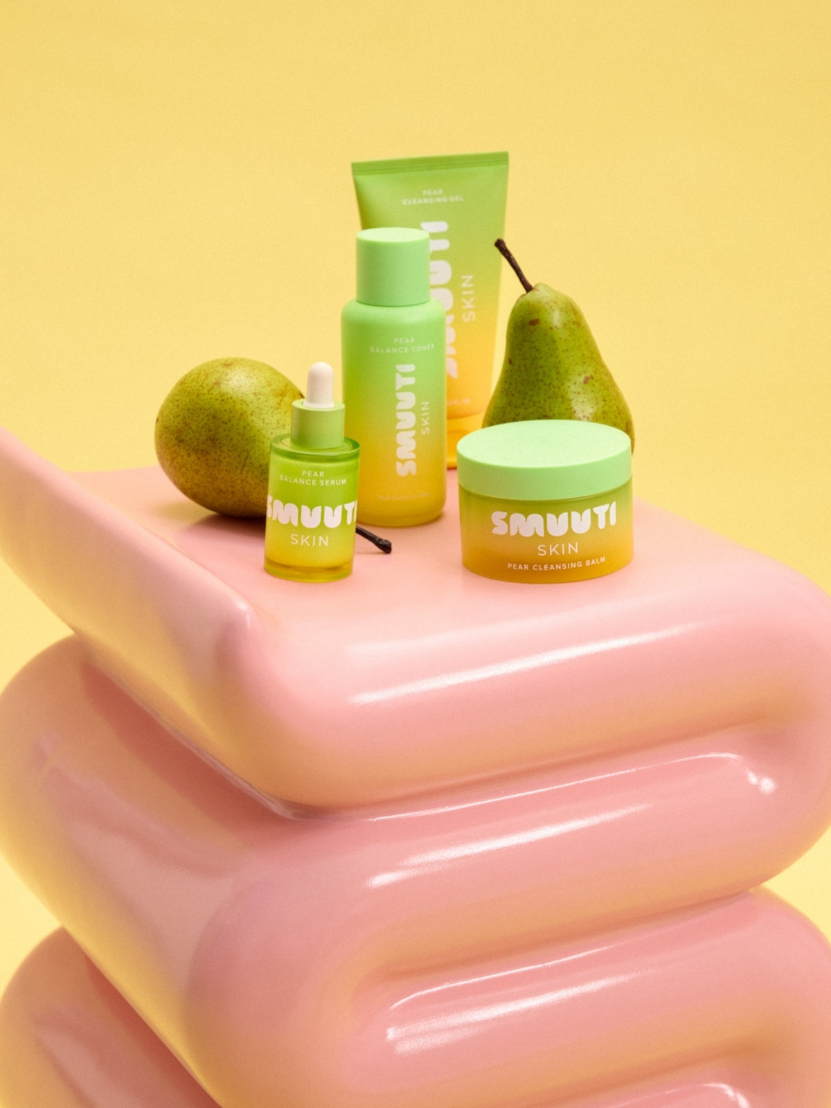 Smuuti Skin pear balance Skincare products with pears on a pink surface against a yellow background