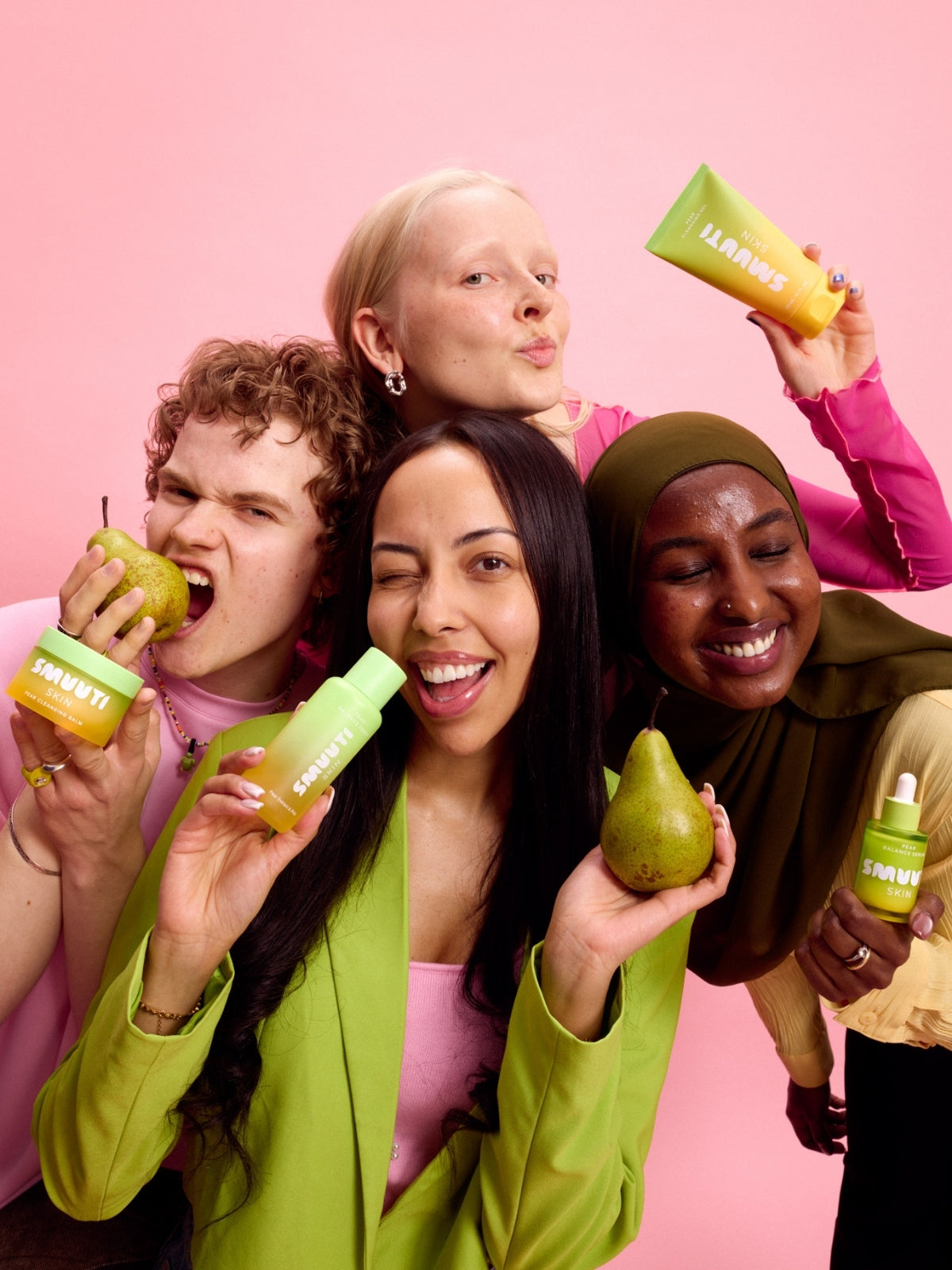 Four people holding pears and Smuuti Skin pear balance skincare products against a pink background