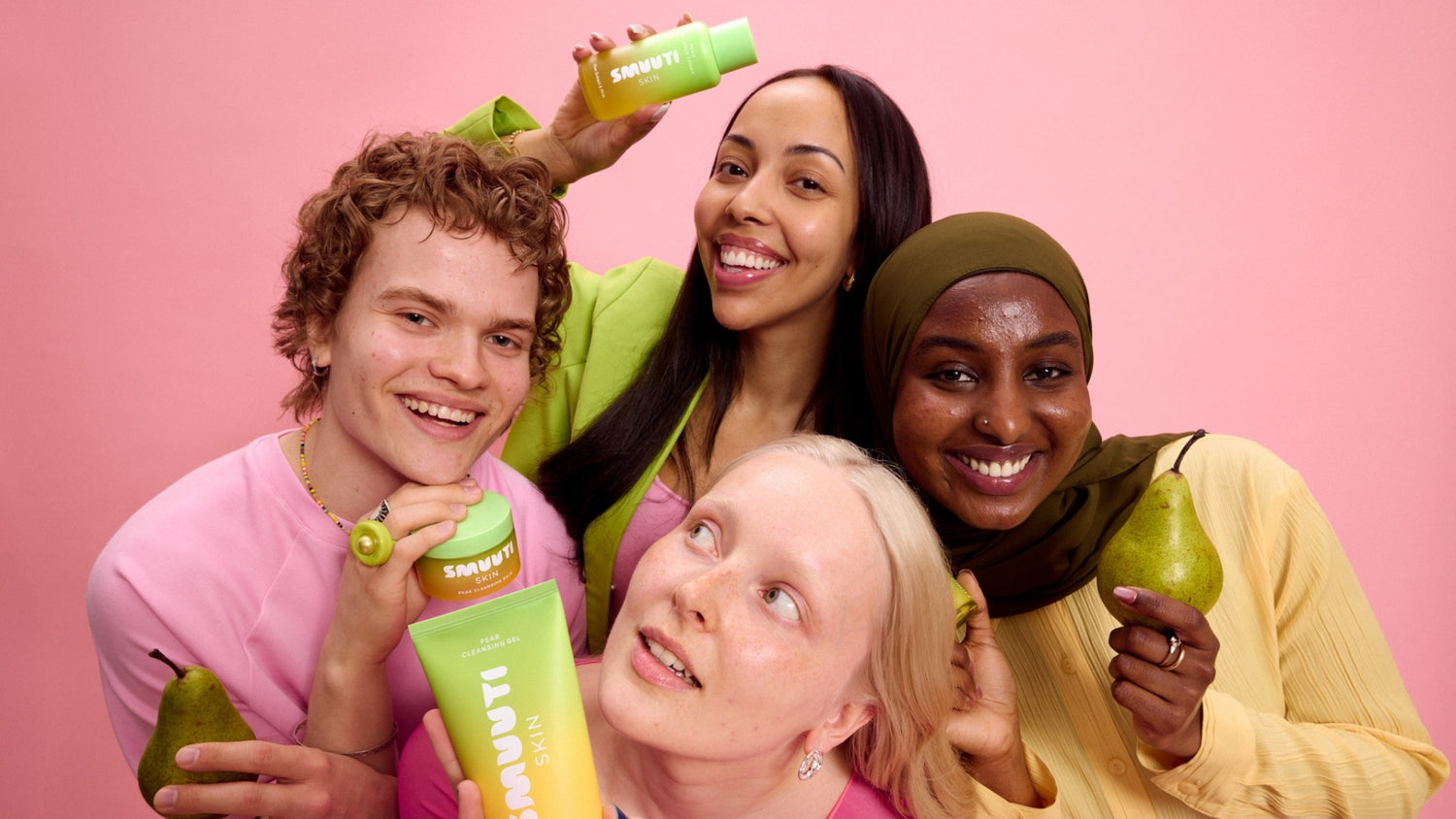 Four people holding pears and Smuuti Skin pear balance products against a pink background
