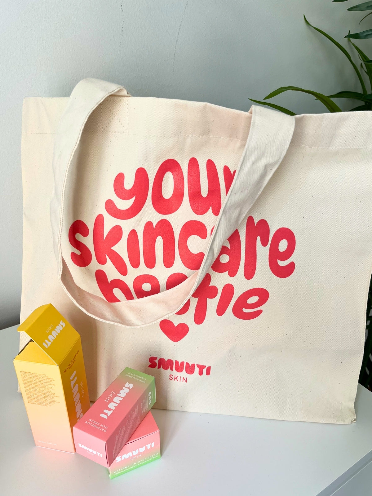 Tote bag with 'Your Skincare Bestie' text and Smuuti Skin skincare products on a light surface.