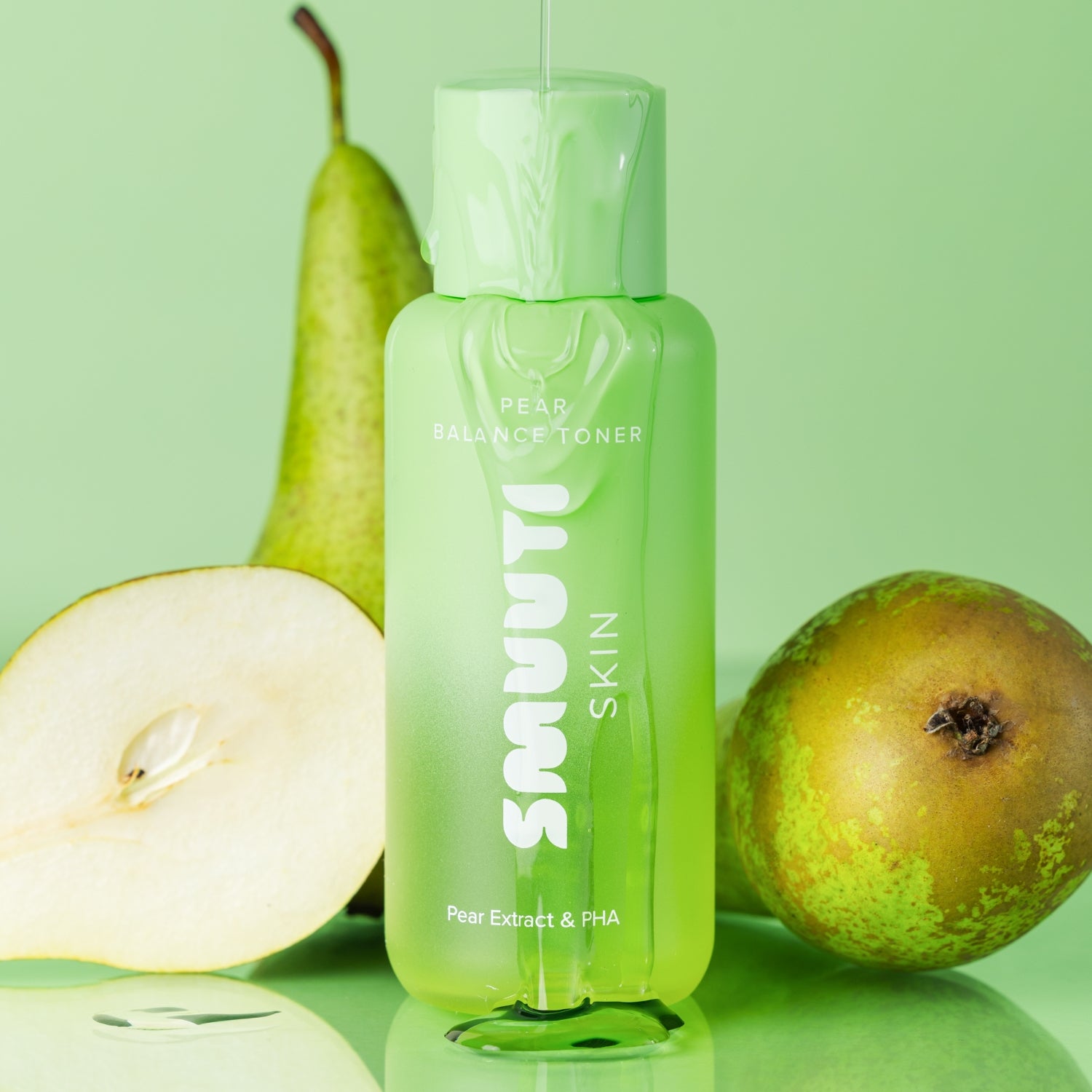 Green bottle of smuuti skin pear balance toner with pears on a green background