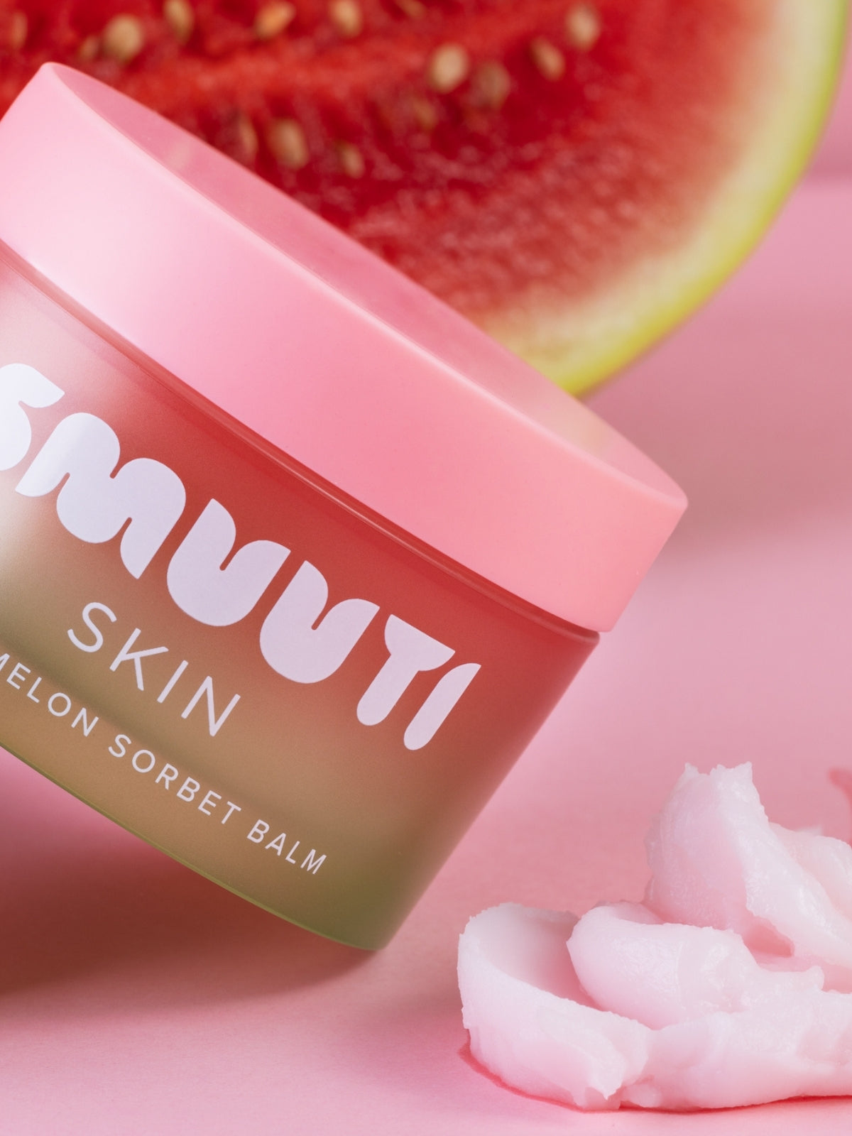 Jar of Smuuti Skin Watermelon Sorbet Balm with watermelon slices on a pink background