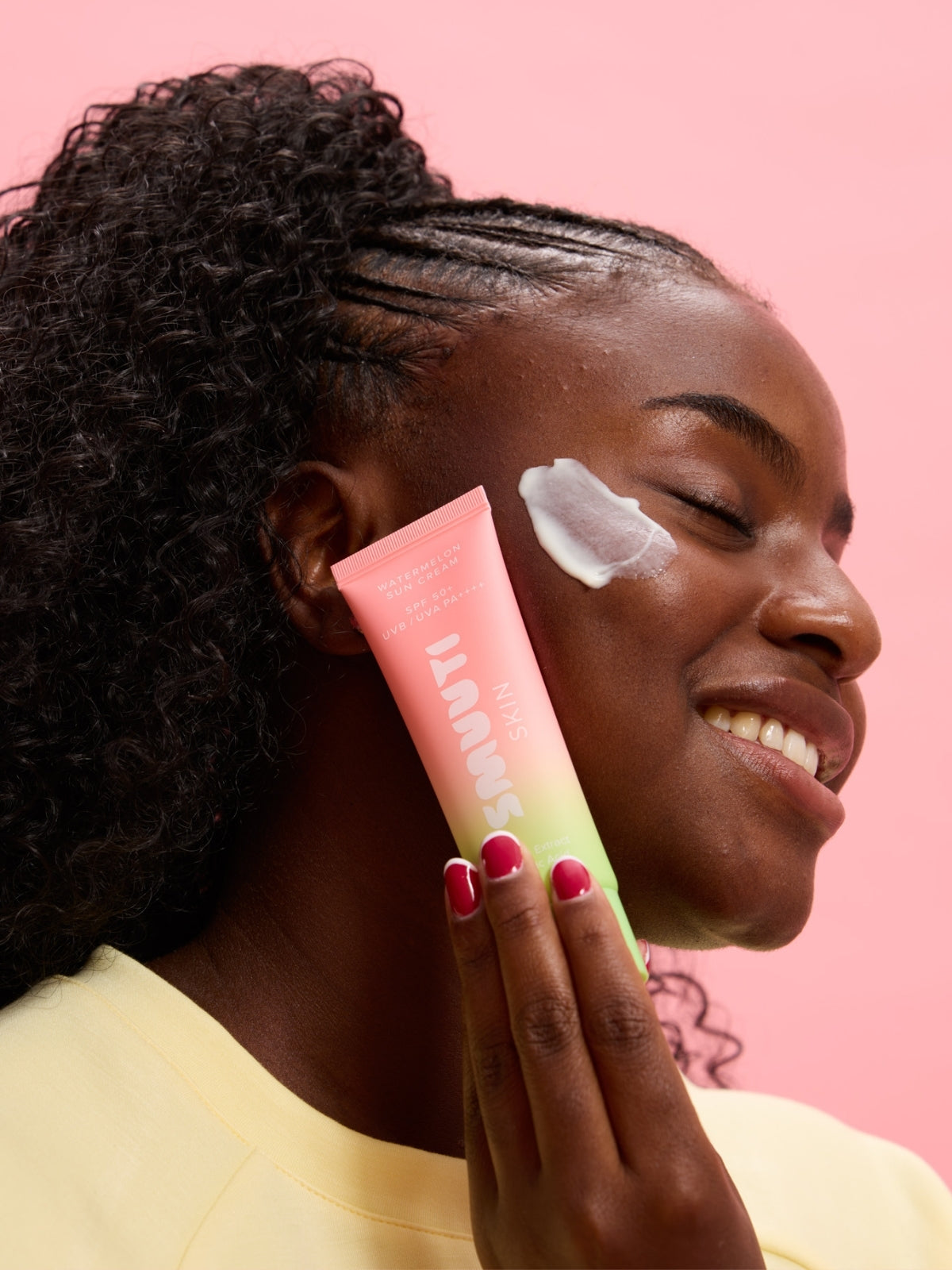 Woman applying Smuuti Skin watermelon sun cream to her face
