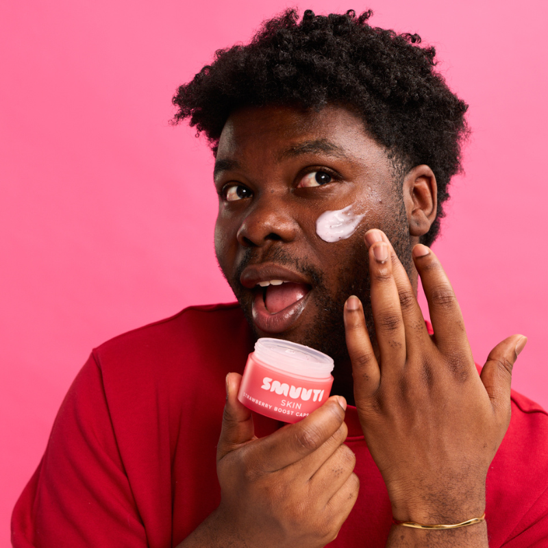 A man applying Strawberry Boost Capsule Cream on his face