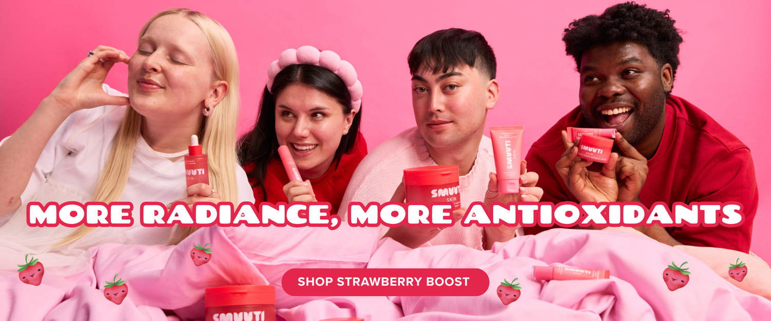 Four people lying on a pink bed holding red strawberry boost skincare tubes, with a pink background and the text 'MORE RADIANCE, MORE ANTIOXIDANTS' and 'SHOP STRAWBERRY BOOST'.