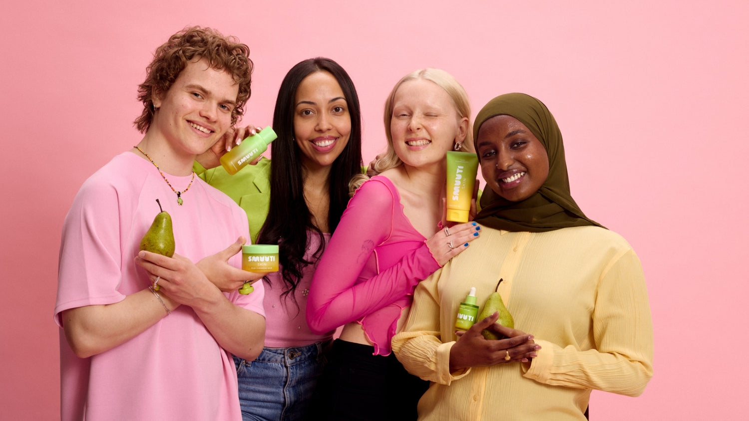 Four people holding Smuuti Skin pear balance skincare products and pears against a pink background
