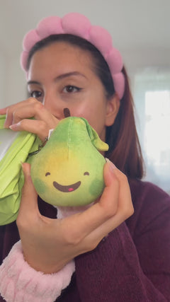 person showing and squeezing soft pear keychain