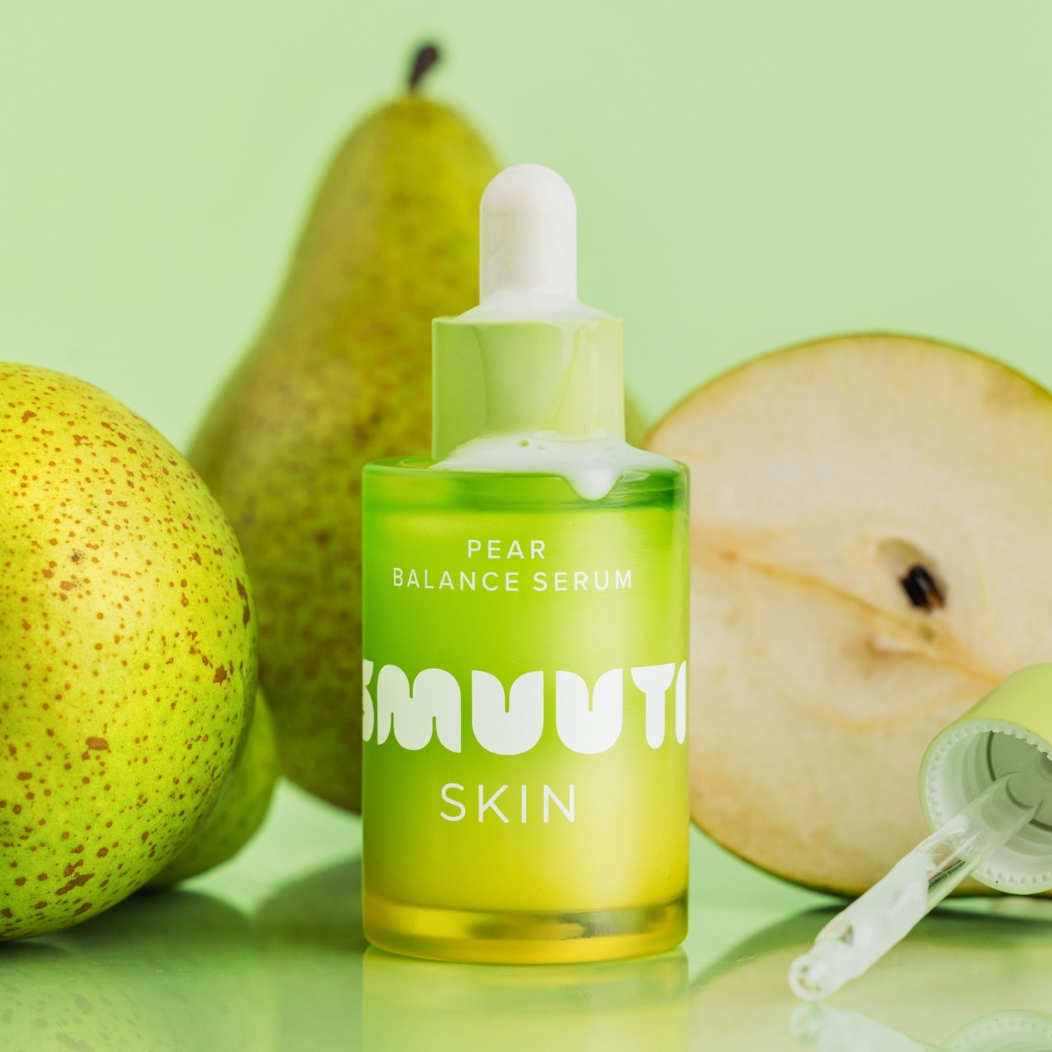 Pear balance serum bottle with pears on a green background