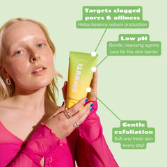 Woman holding smuuti skin pear cleansing gel with text highlighting its benefits on a green background