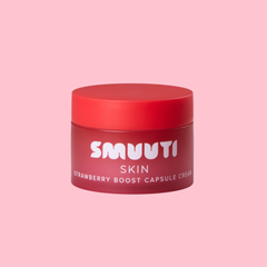 A red cosmetic jar labeled 'SMUUTI SKIN Strawberry Boost Capsule Cream' centered on a solid pink background.